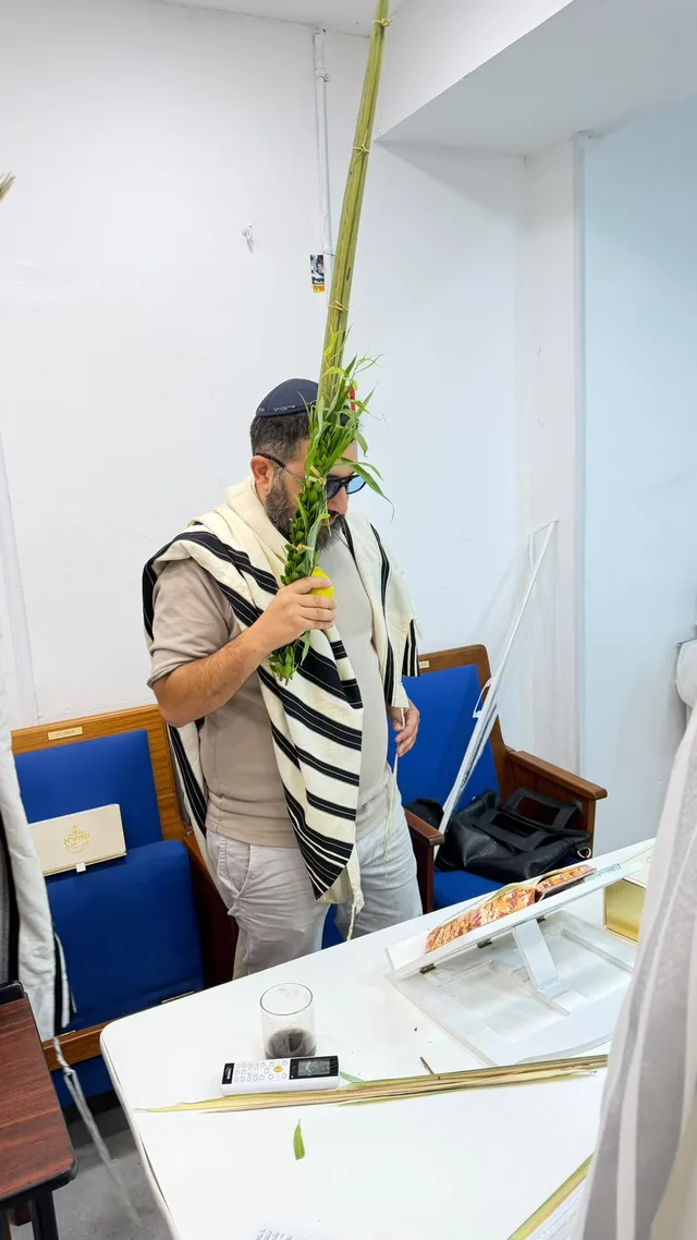 מתפלל עטוף בטלית עם לולב